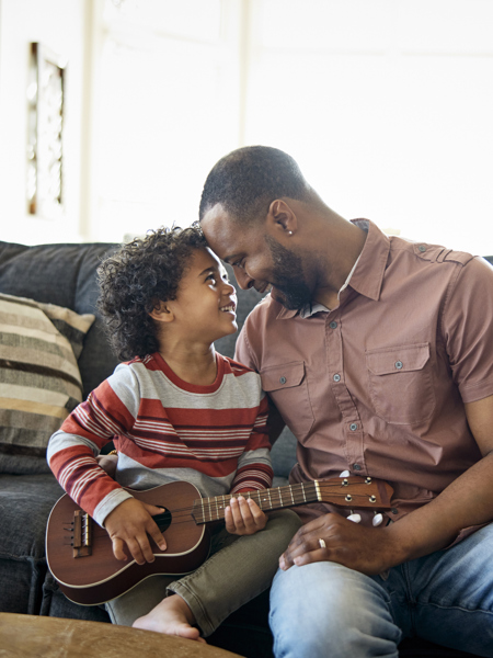 Father and son sitting on sofa with a guitar.jpg