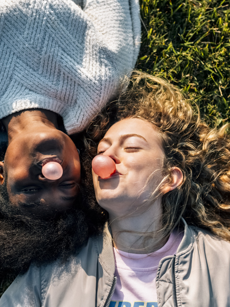 Two women lying on grass blowing bubblegum bubbles.jpg